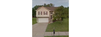 A house with a brown roof and a white garage door.