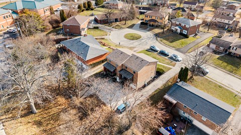 A bird's eye view of a residential area with houses and cars.
