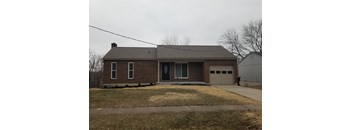 A house with a grey garage door and a black door.