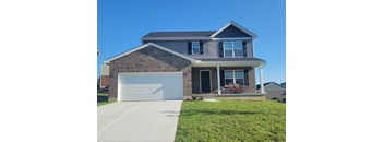 A house with a garage door and a covered porch.