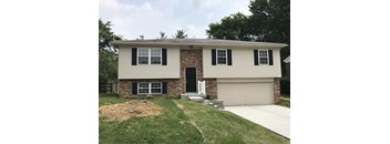 A two-story house with a garage and a driveway.