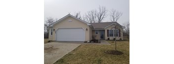 A house with a garage door and a brown roof.