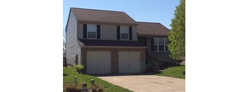 A two-story house with a garage and a driveway.