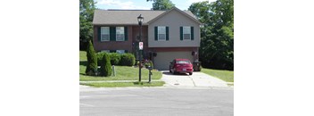 A red car is parked in front of a house.