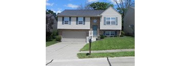 A house with a grey garage door and a mailbox on the sidewalk.