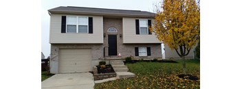 A house with a brown and beige exterior and a black door.
