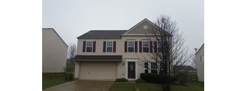 A two-story house with a garage and a driveway.