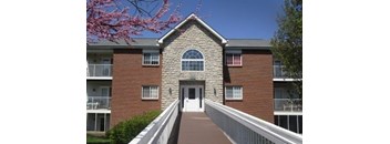 A brick building with a white door and windows.