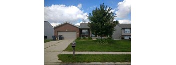 A house with a brown roof and a grey garage door.