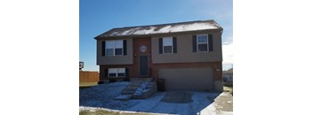 A house with a brown brick facade and a grey garage door.