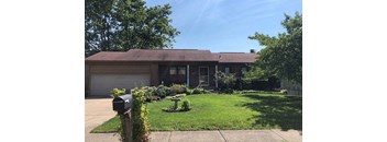 A house with a brown roof and a mailbox in front.