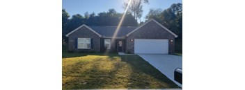 A house with a garage and a driveway is captured in the image.