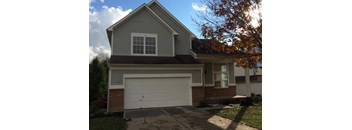 A house with a grey roof and a white garage door.