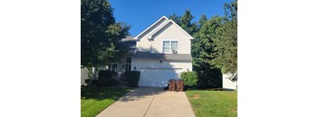 A white house with a garage and a driveway.