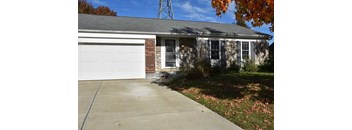 A house with a white garage door and a brick chimney.