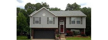 A house with a grey roof and a red door.