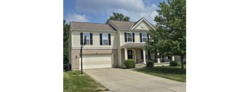 a tan brick house with a white garage door