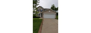 A two-story house with a garage and a driveway.