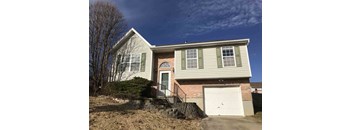 A house with a grey siding and a white garage door.