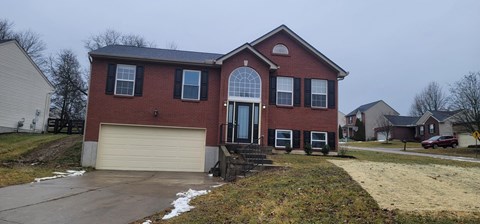 a red brick house with a white garage door