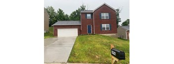 A brick house with a black mailbox on the front.