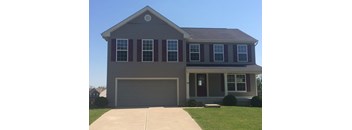 A house with a grey roof and red shutters.