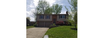A house with a grey garage door and a brick chimney.