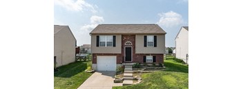 A house with a brick archway entrance and a white garage door.