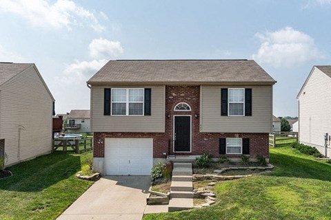 A house with a brick archway entrance and a white garage door.