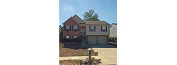 A house with a brown roof and a white garage door.