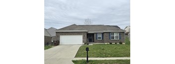 A house with a grey roof and a white garage door.