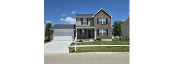 a brick house with a white garage and a driveway