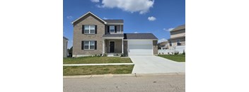 a brick house with a white garage door and a sidewalk in front