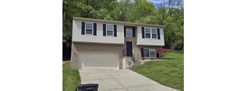 a white house with black shutters and a driveway