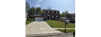 A two-story house with a garage and a driveway in front.