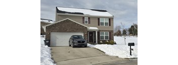 A house with a car parked in front of it.