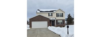 A house with a snow-covered roof and a mailbox in front.