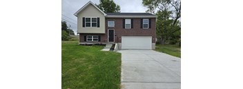 A house with a garage door and a driveway.