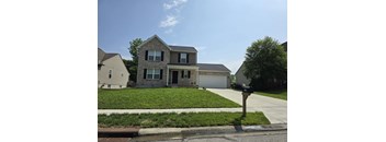 A house with a grey roof and a white garage door.
