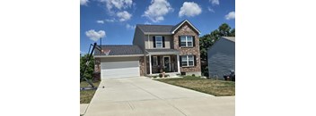 A house with a basketball hoop in the backyard.