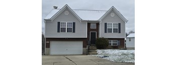 A house with a grey siding and a white garage door.