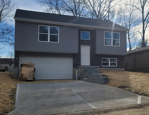 a gray house with a driveway and a white garage door