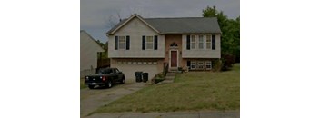 A house with a car parked in front.