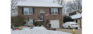 A house with a white car parked in front.