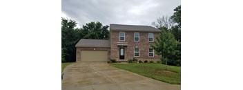 a brick house with a garage and a driveway