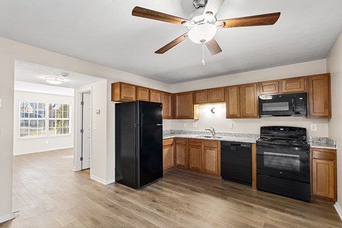 A kitchen with black appliances and wooden cabinets.