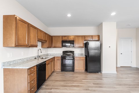 A kitchen with wooden cabinets and black appliances.
