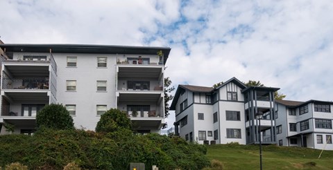 A large white building with a balcony on the second floor.