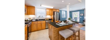 A kitchen with wooden cabinets and a black countertop.