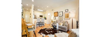 A living room with a couch, chair, and pictures on the wall.